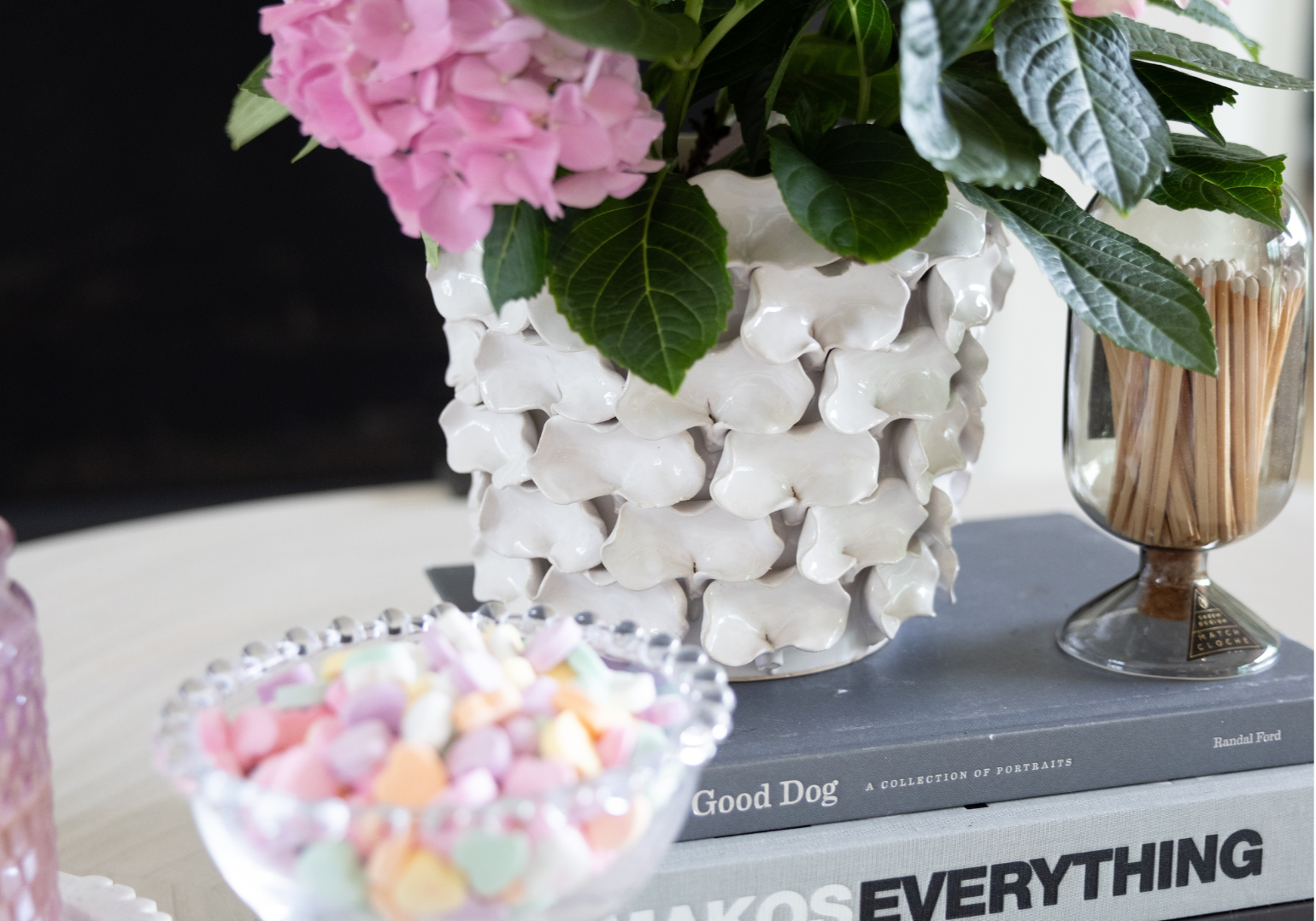 coffee table with books, flowers, and candy hearts on top